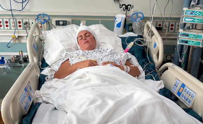 Angie resting in a hospital bed after surgery